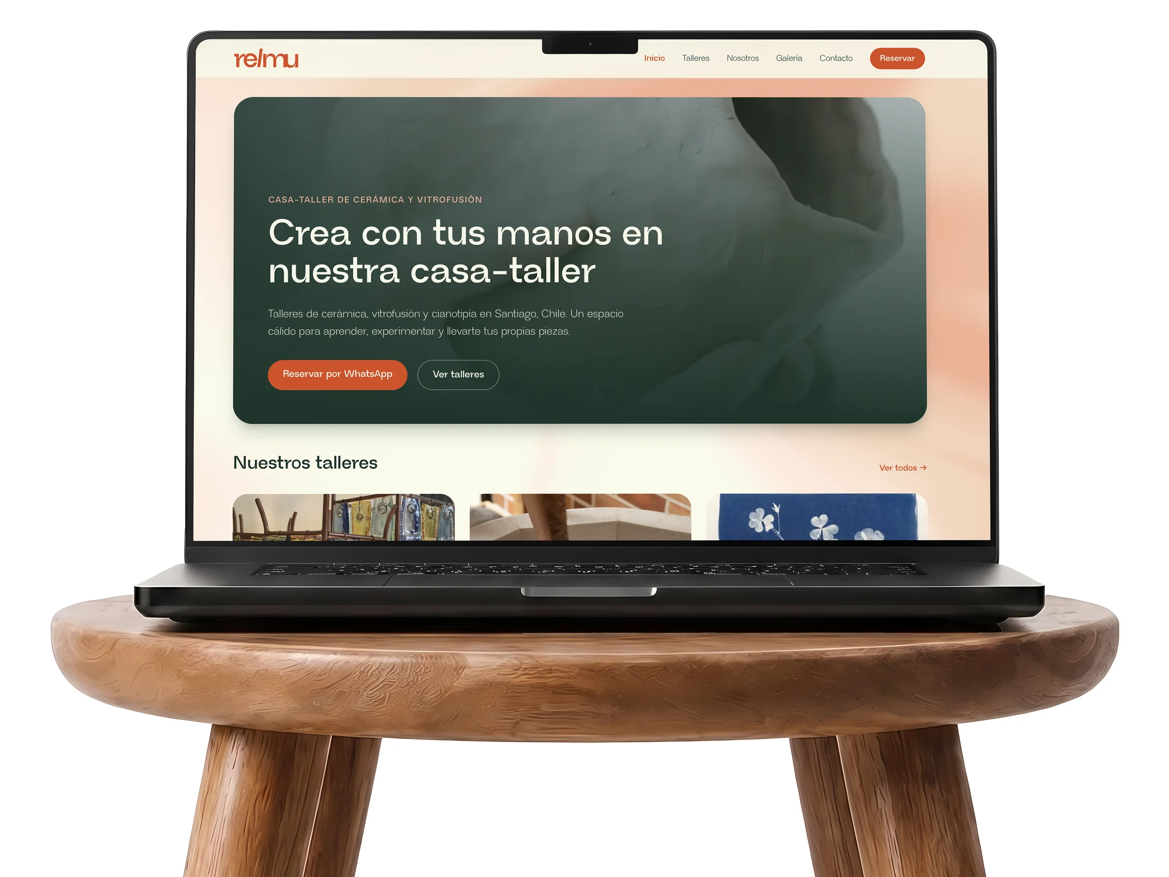 El sitio de Relmu en un MacBook sobre un piso de madera