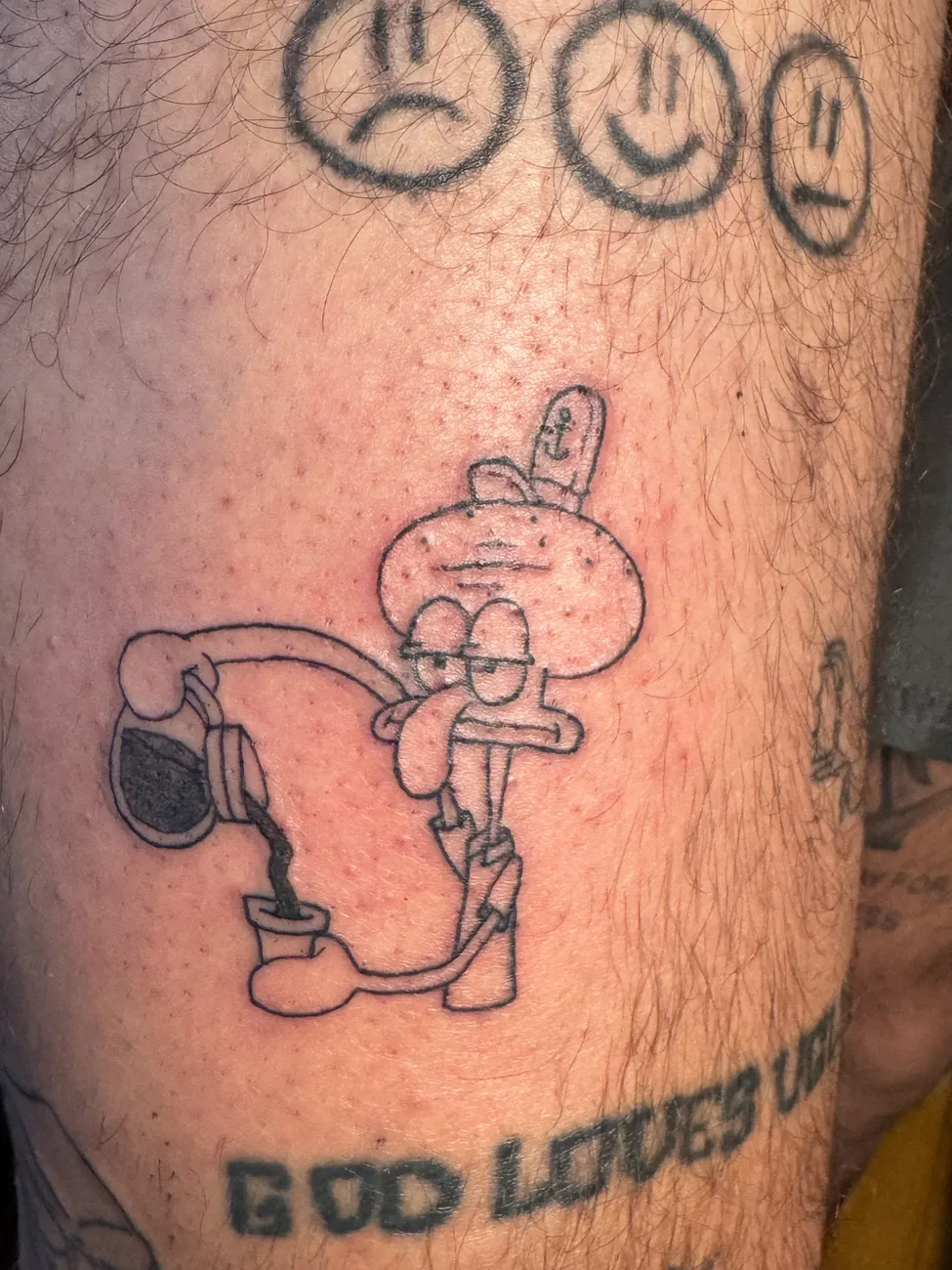 Tatuaje de Squidward con audífonos y tres caritas